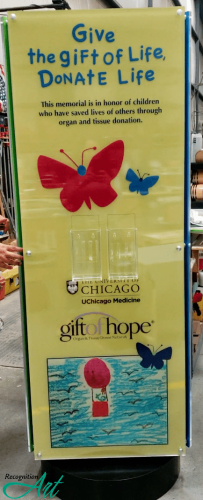 Freestanding rotating donor displays for the University of Chicago Hospital and Gift of Hope. This three sided rotating display is themed with butterflies and recognizing those who gave the ultimate sacrifice in donating organs and tissue. The panel is in yellow and features brochures for how you can give back to Gift of Hope and the University of Chicago Hospital.